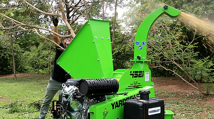 a tree care operator utilizing a commercial wood chipper and chipping thick riddled branches demonstrating how a commercial chipper can save work by avoiding less pruning